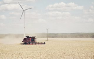 Campo de trigo, tractor y molino eólico